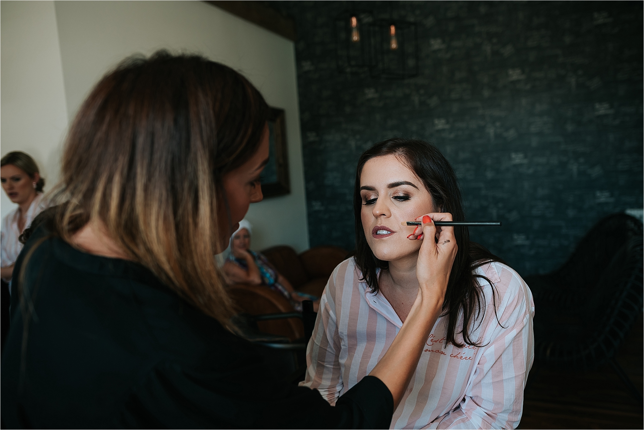 bride having her make up done at holmes mill