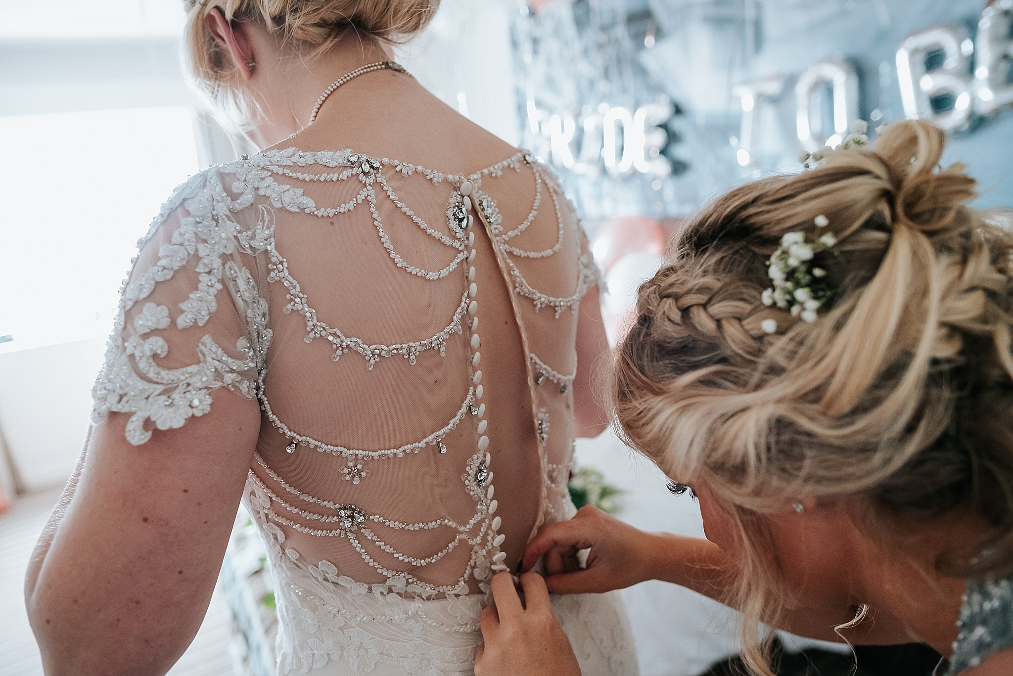 bride having her dress done up