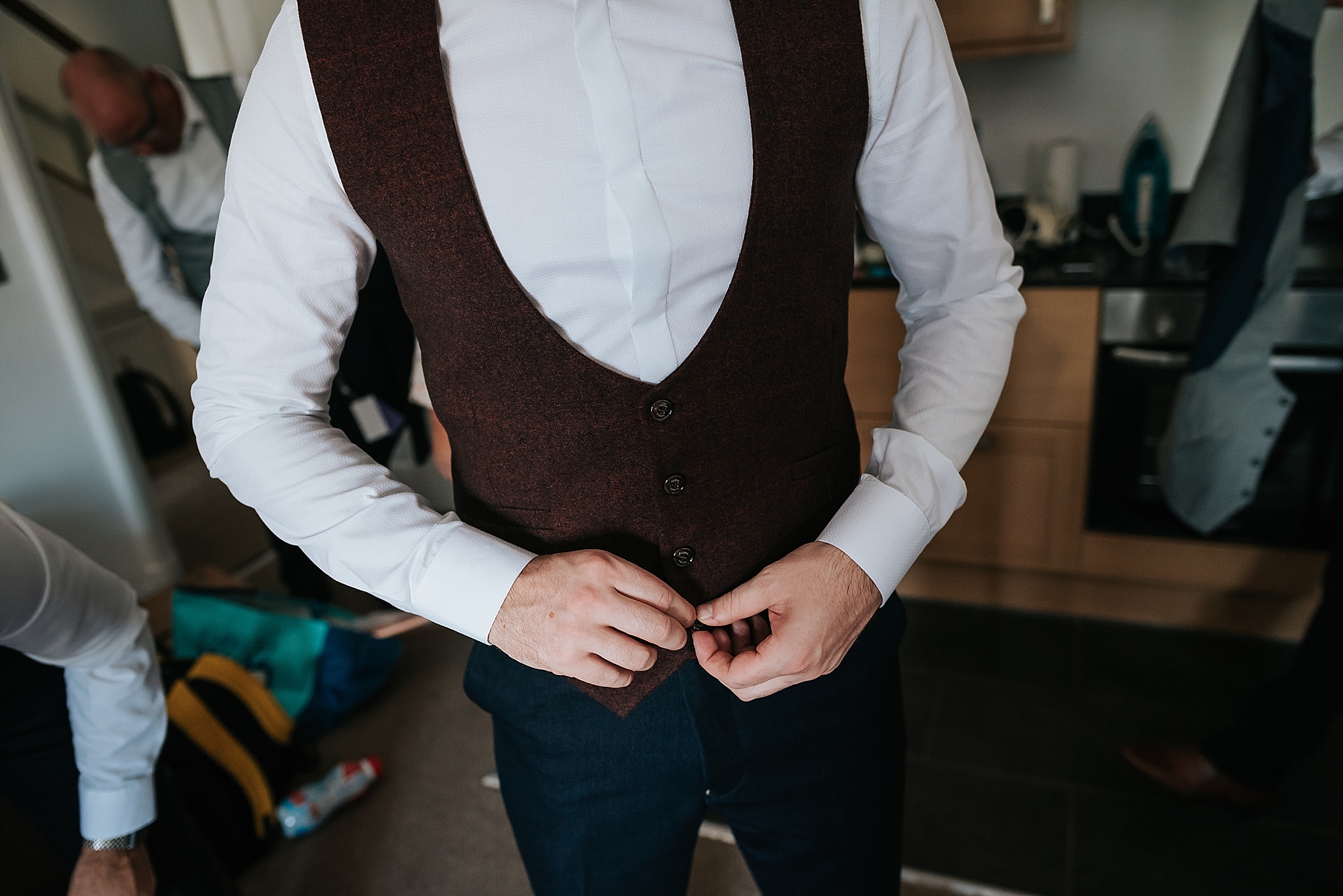 groom puts his suit on