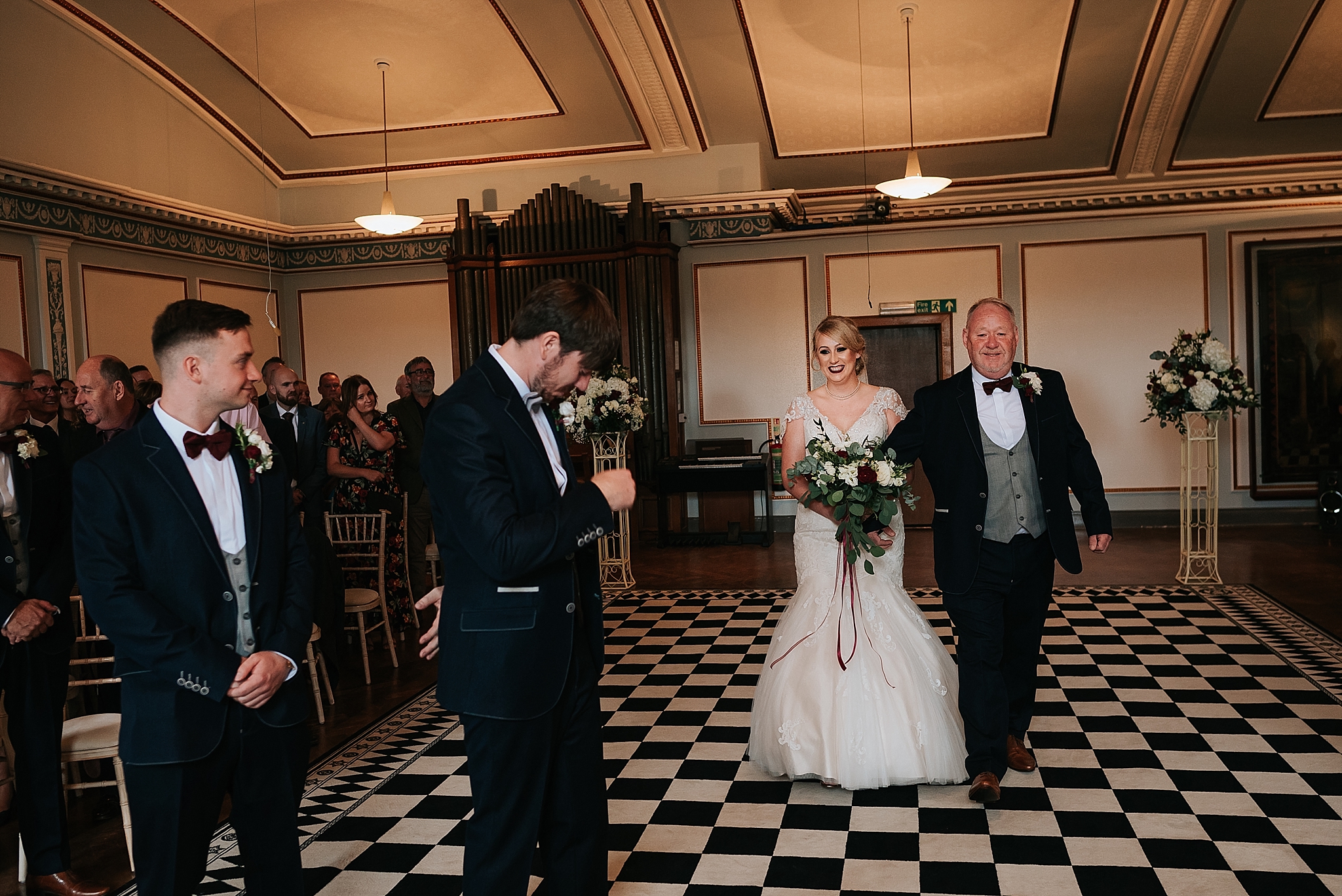 bride walks down the aisle at wedding at st annes palace 