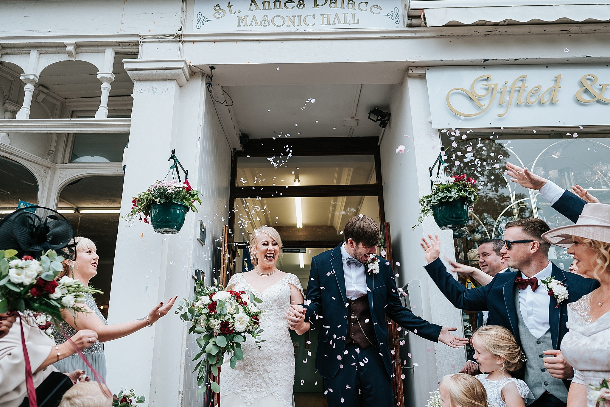 bride and groom having confetti thrown at them outside vintage wedding venue in lancashire 