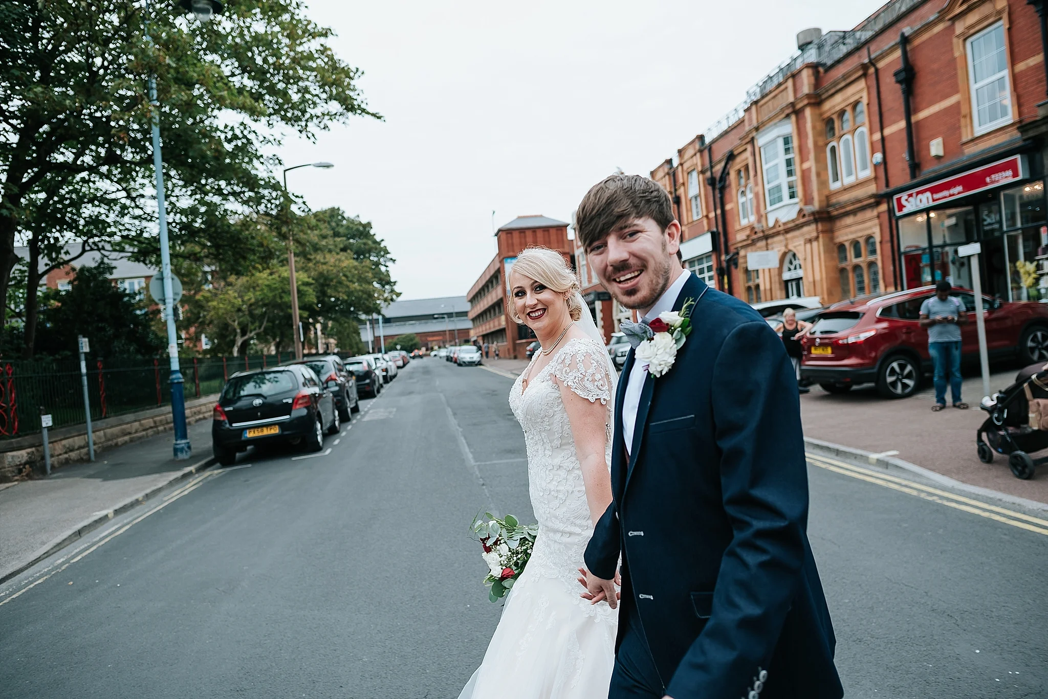 cool bride and groom walking across the road in st annes