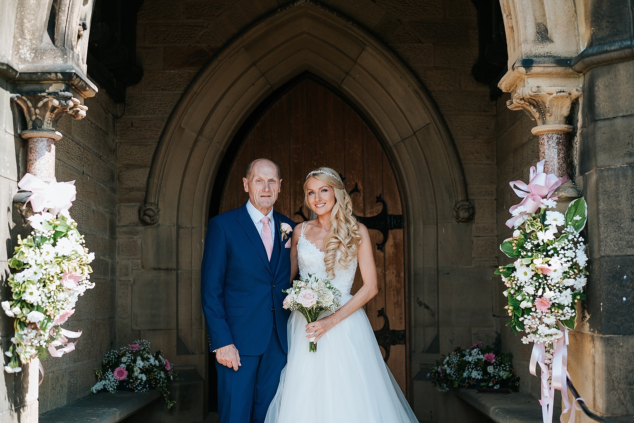 bride with father at all saints church in preston