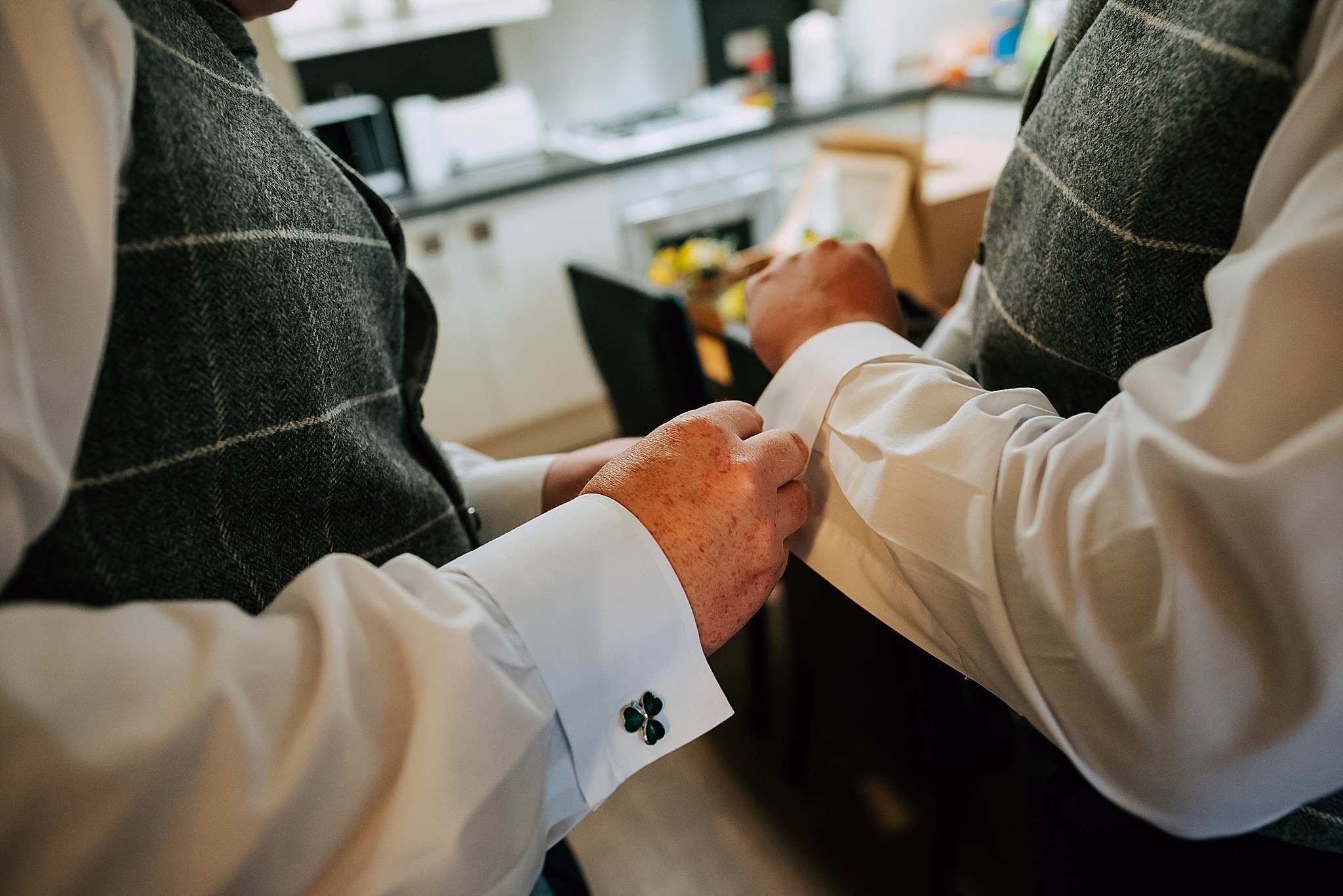 groom and best man put cuff links on