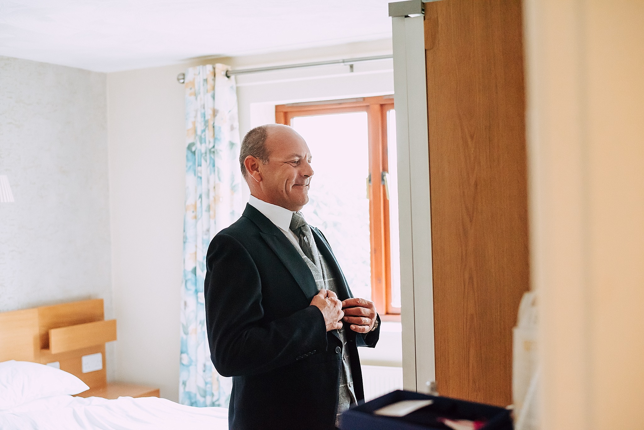 father of the groom gets ready at wedding