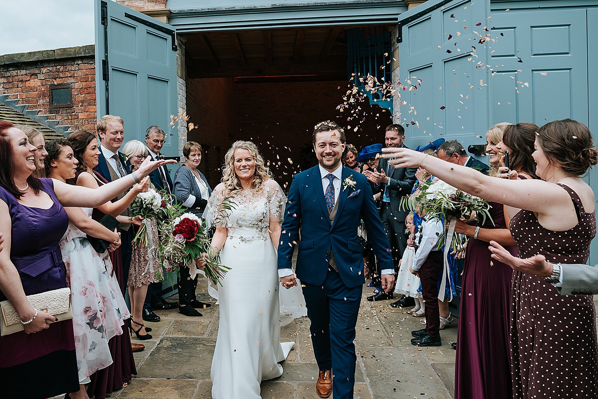 bride and groom get showered in confetti at dorfold hall in cheshire 