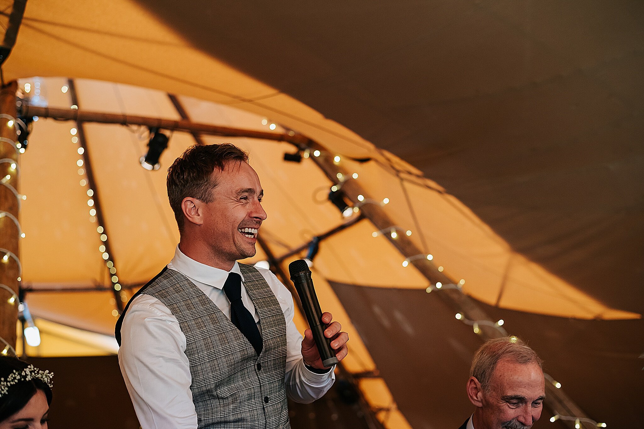 groom laughing at tipi wedding 