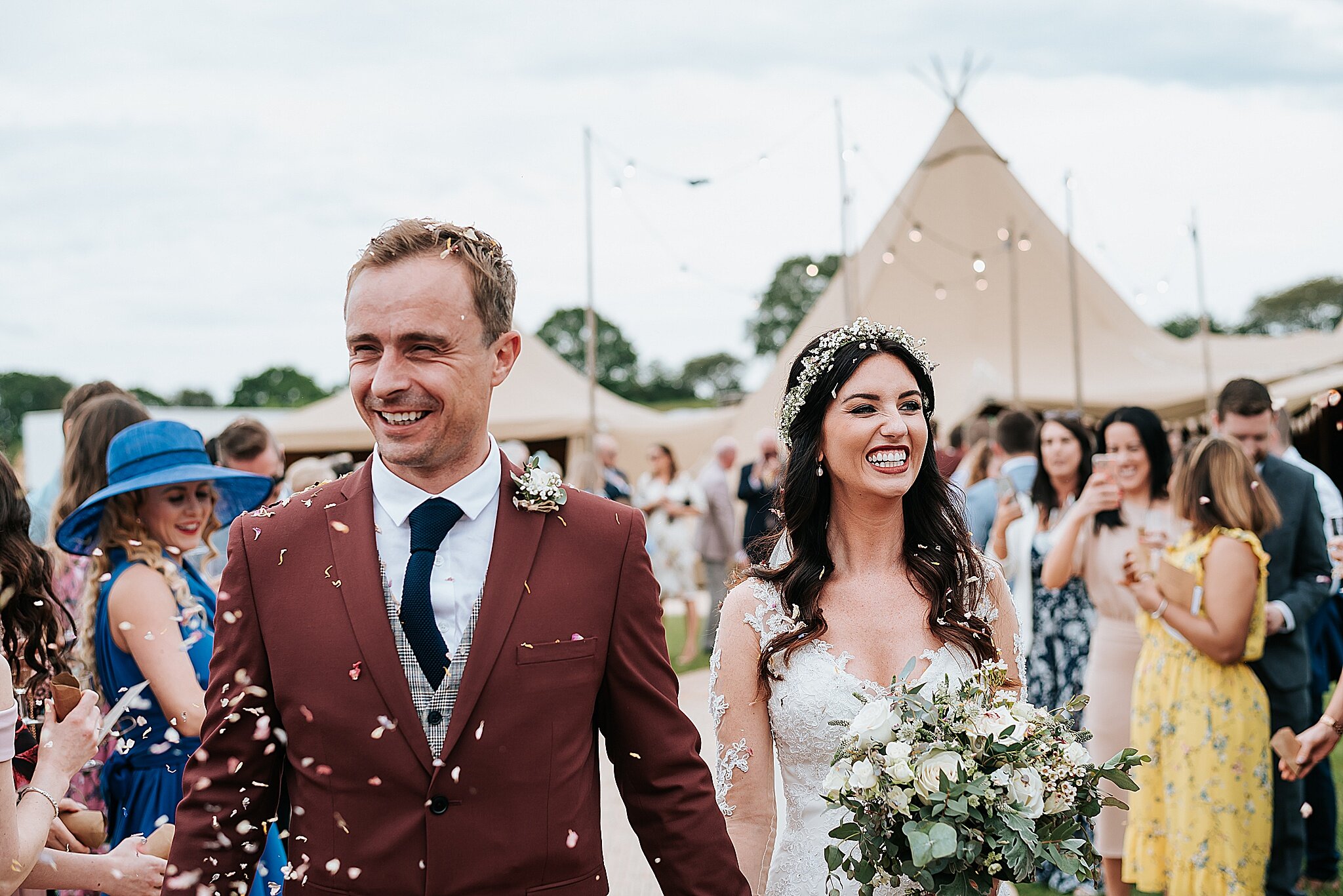 bride and groom in confetti at tipi wedding 
