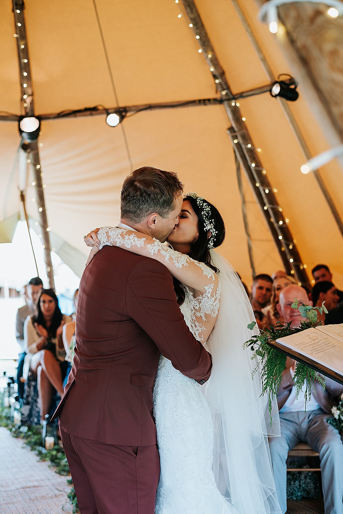 bride and groom kiss in tipi wedding 