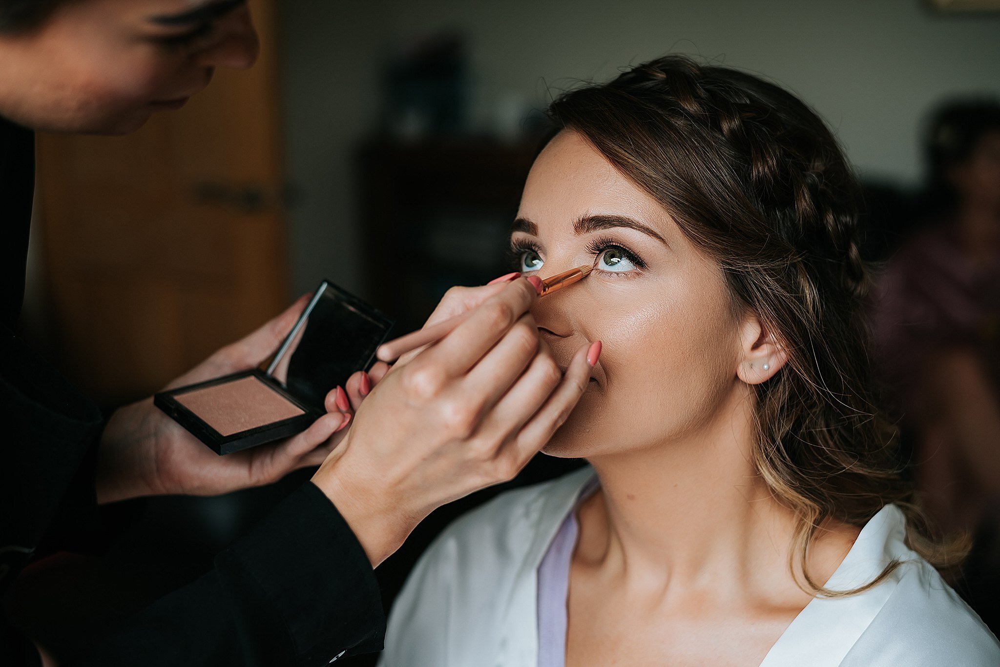 bride has her make up done before wedding 