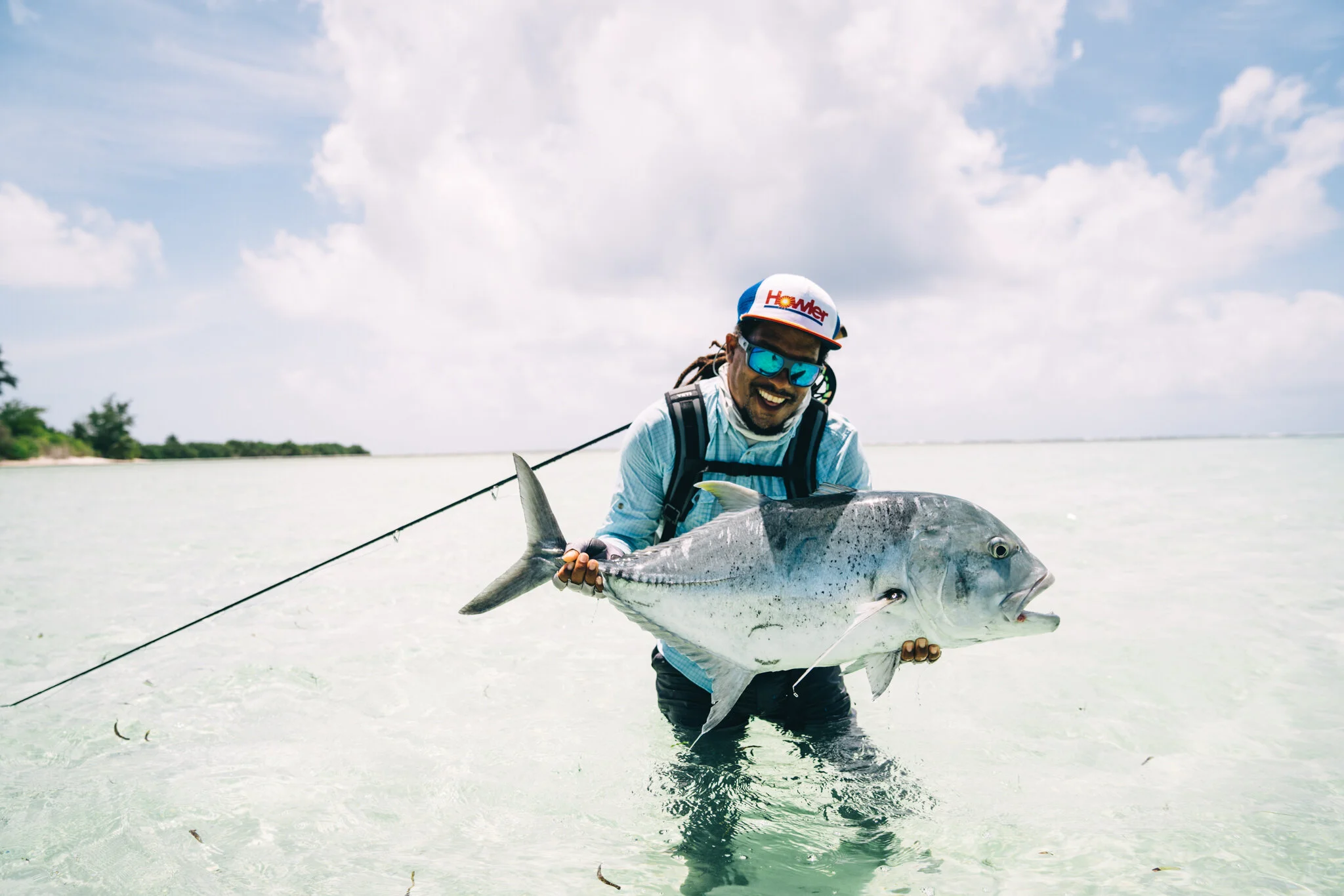 Alvin Dedeaux holding a giant trevally on a fly-fishing expedition