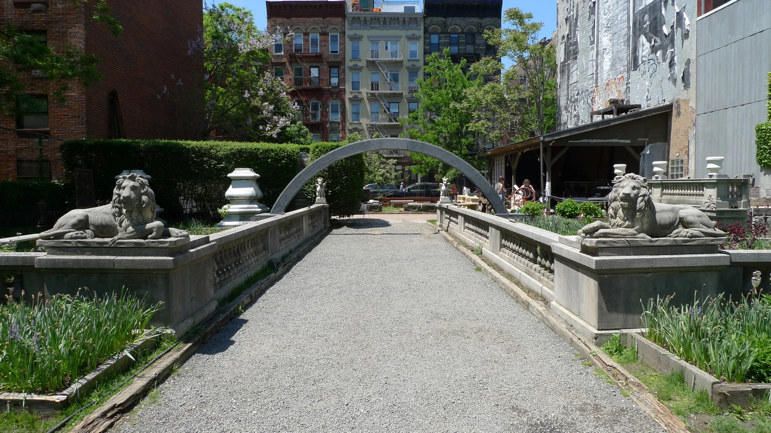   Hold Me in Your Long Arms . An arch connects two benches on either side of a walkway. Installation view at the Elizabeth Street Garden as a part of  A Particular Kind of Solitude  curated by Serra Sabuncuoglu. 25' long x 10' tall. Treated lumber, h