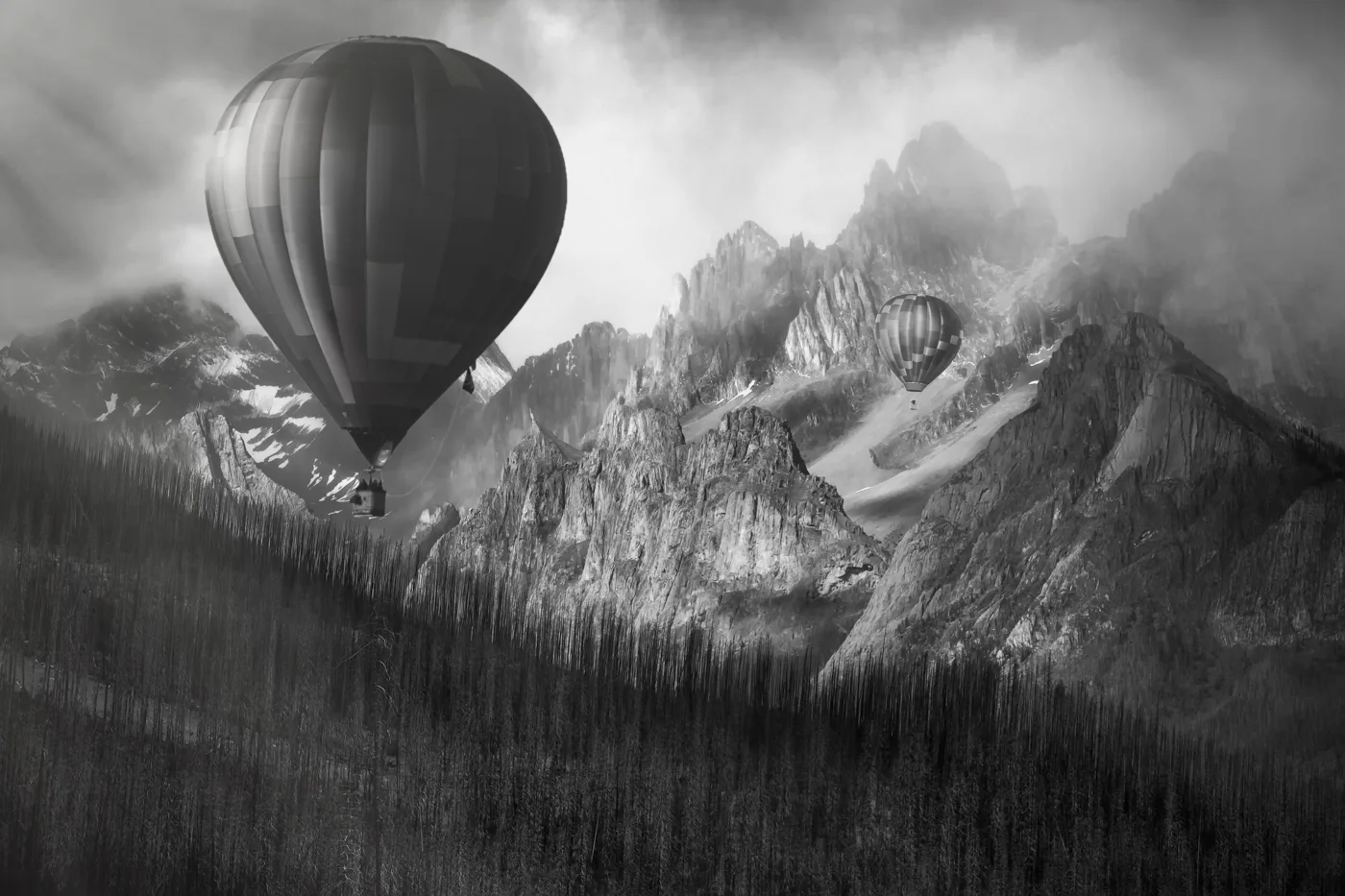 This dynamic image is contrasted both in tone and subject. the fragile round balloons and jagged stormy peaks.