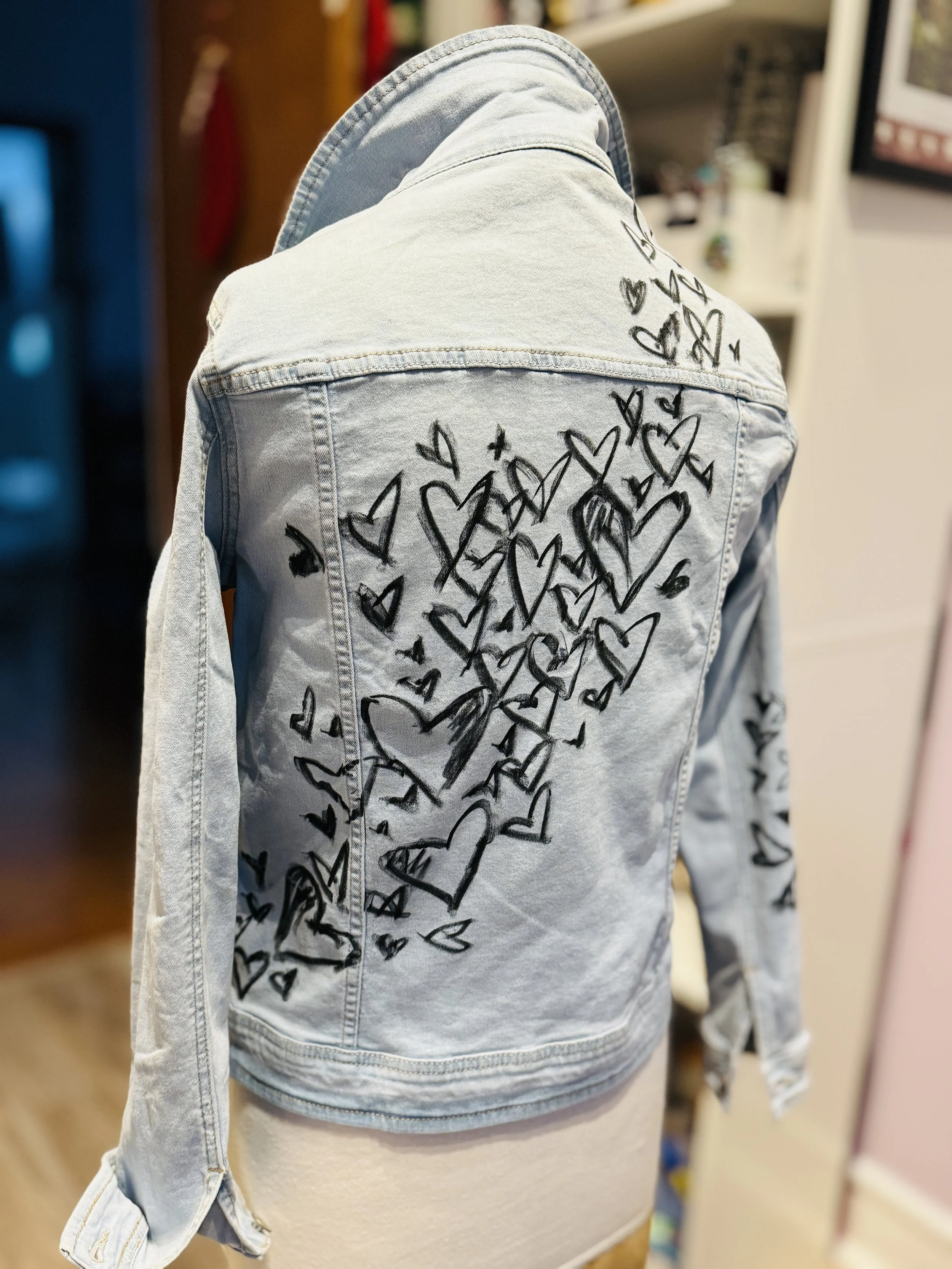Custom hand-painted denim jacket with bold heart designs for a wedding party — wearable art by Danielle Rose Fisher