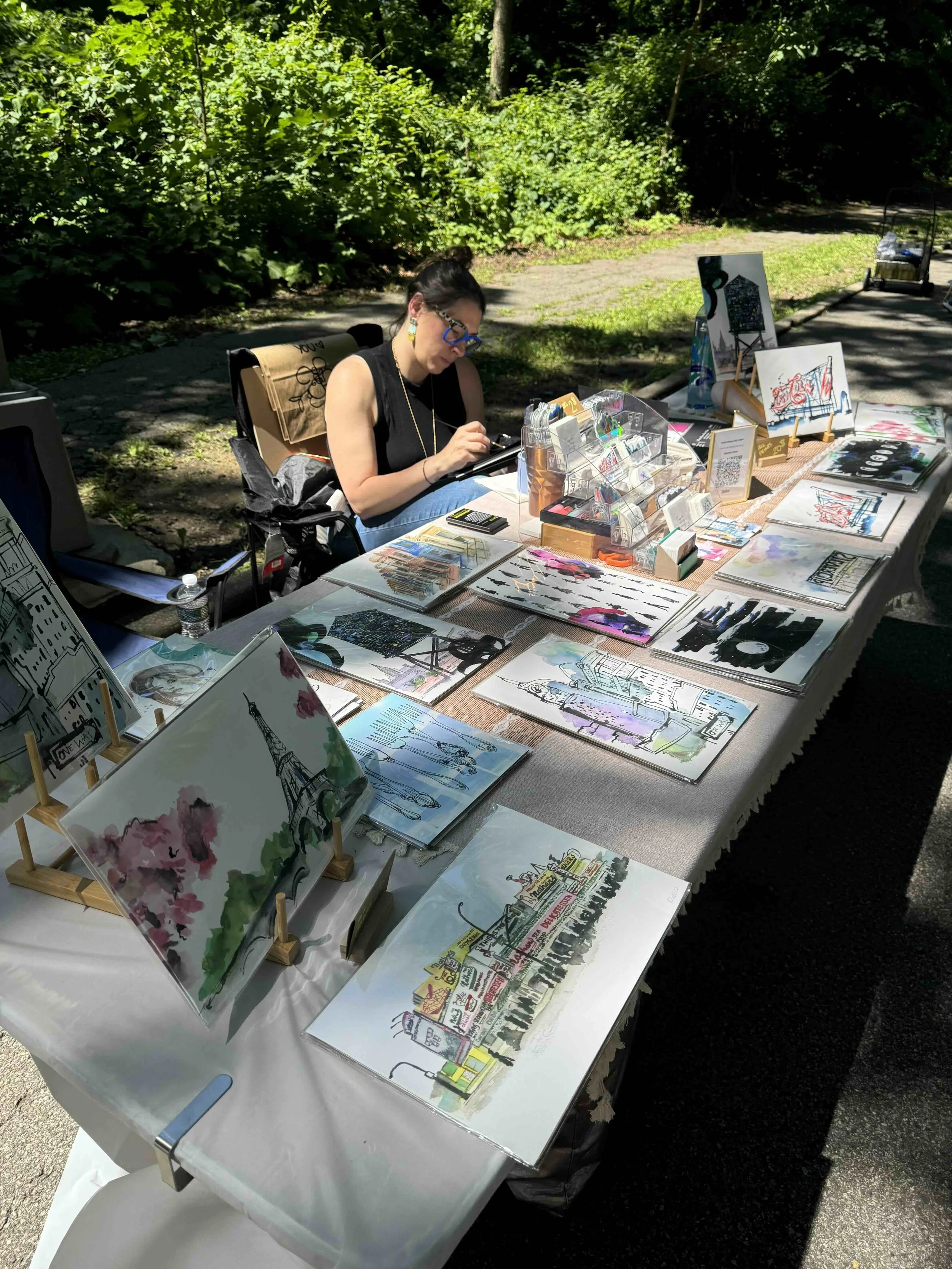 Danielle painting at the fall marketplace, working at her art table, capturing the creative energy of the event.