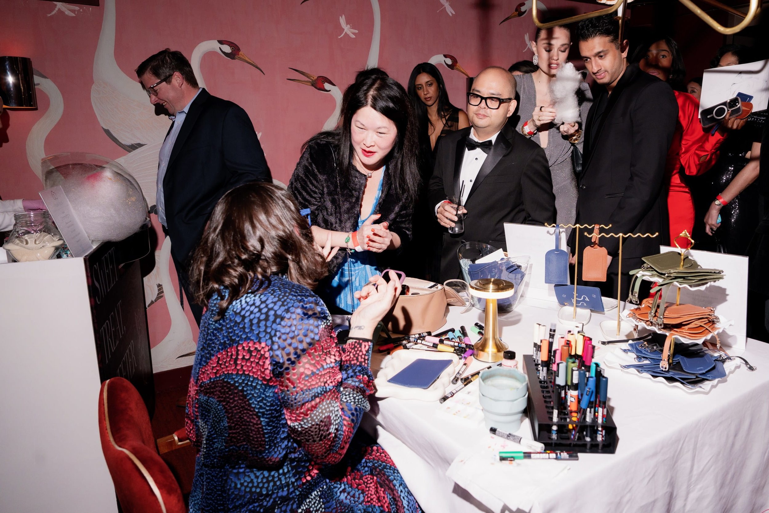 Black-tie guests gathered around Danielle Rose Fisher's illustration station at The Young Angels Gala, Crane Club NYC