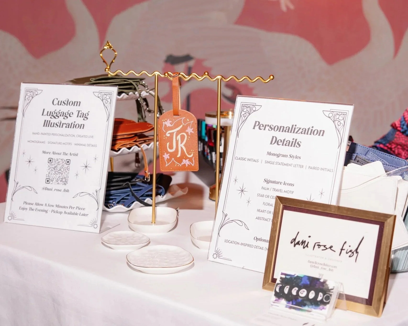 Danielle Rose Fisher's custom illustration station at The Young Angels Gala — personalization menu, luggage tag display, and artist signage