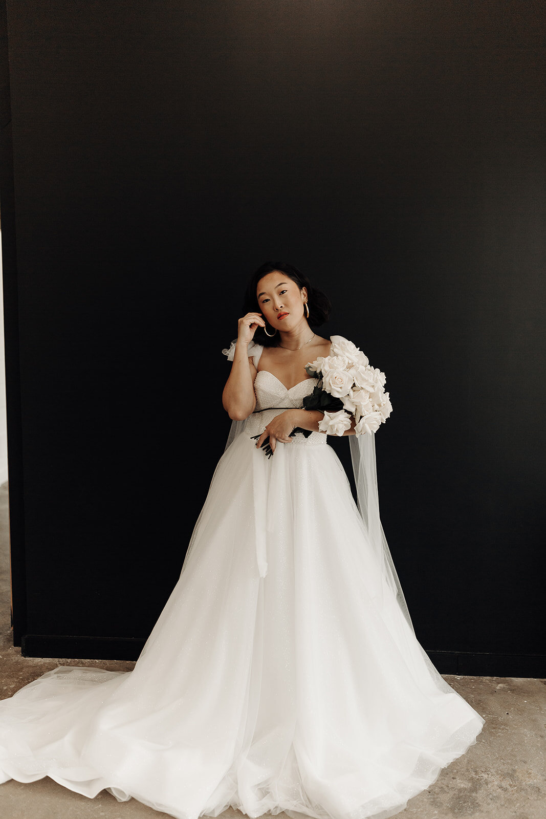 a modern eva lendel wedding dress with a black backdrop from anna be bridal boutique
