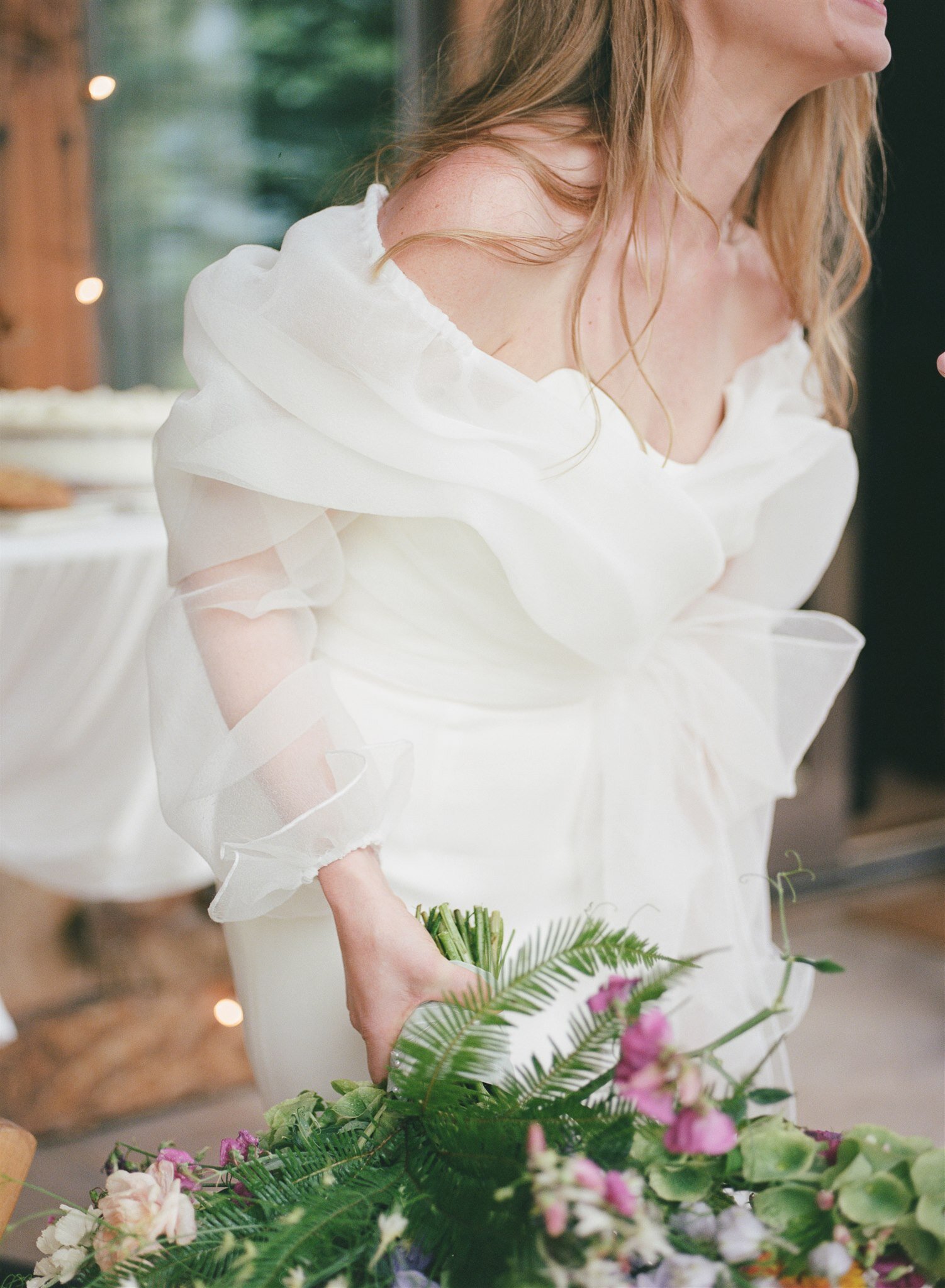  A bride wearing the ROSE blouse by The Label, a long sleeve wrap blouse in a sheer organza 