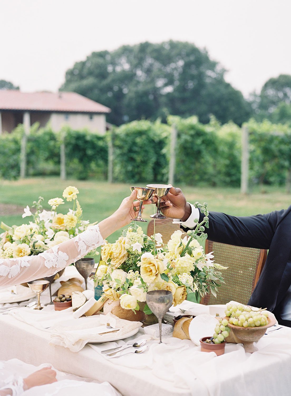  A bride and groom toasting with silver champagne flutes at their spring garden wedding reception in Wisconsin. 