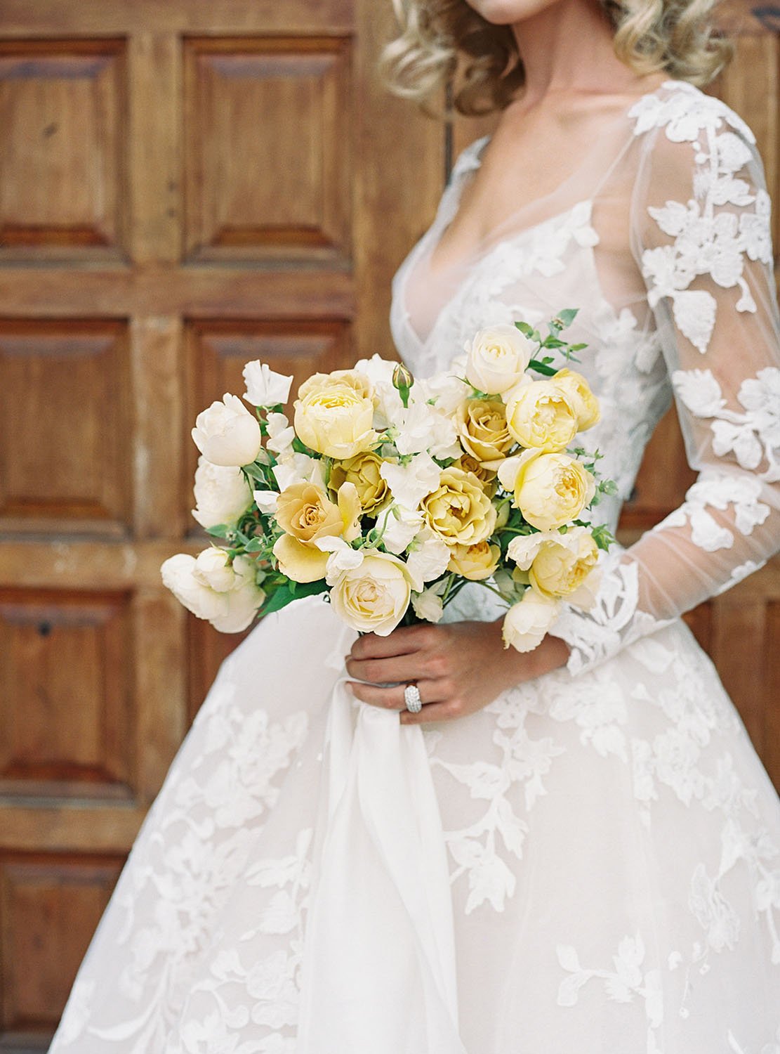  A bride wearing 'Maeve' by Monique Lhuillier wedding dress and holding a gorgeous bridal bouquet of pale yellow and white Davis Austin roses 