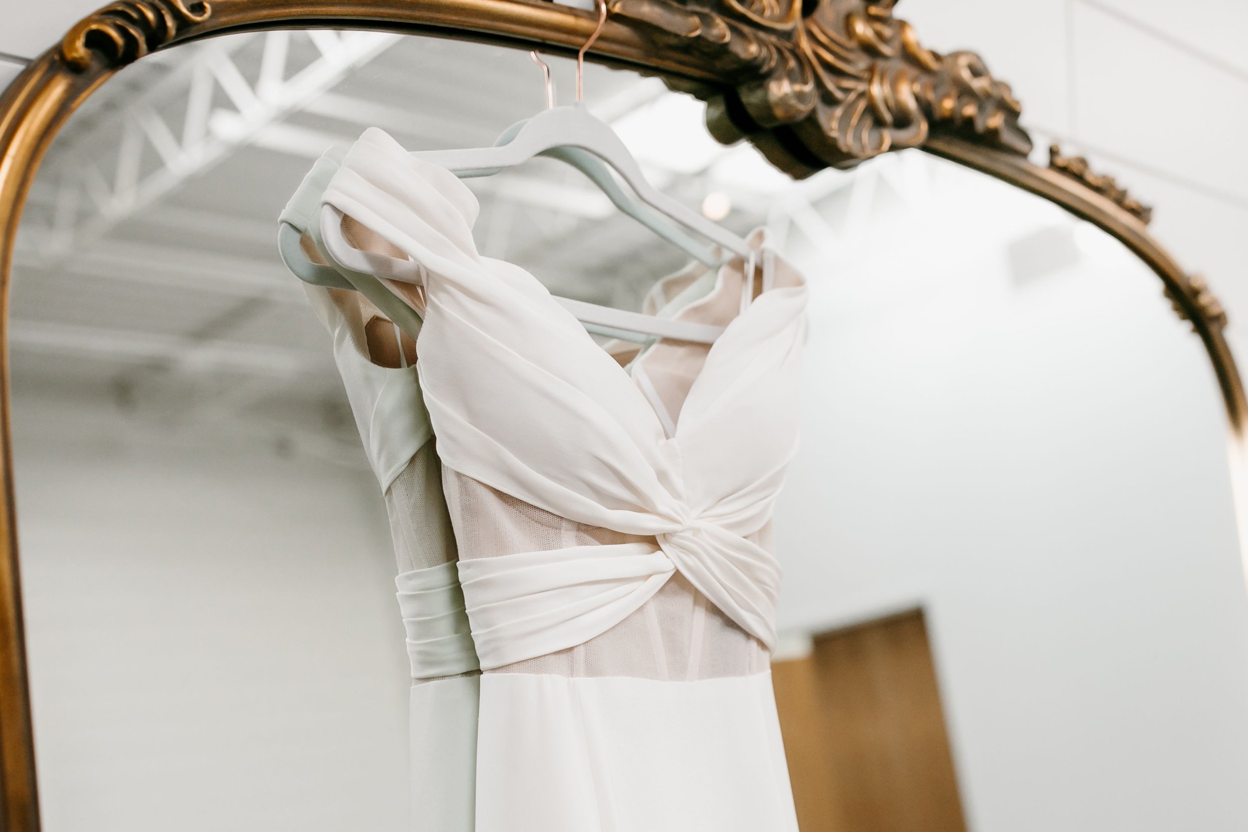 a hanging wedding gown by katherine tash on a gilded anthropologie inspired mirror