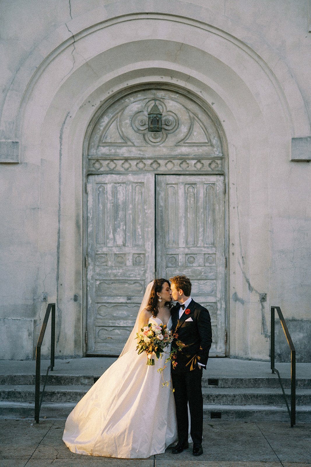 golden hour bridal portraits in front of a restored convent in new orleans featuring a ines di santo statement wedding dress.