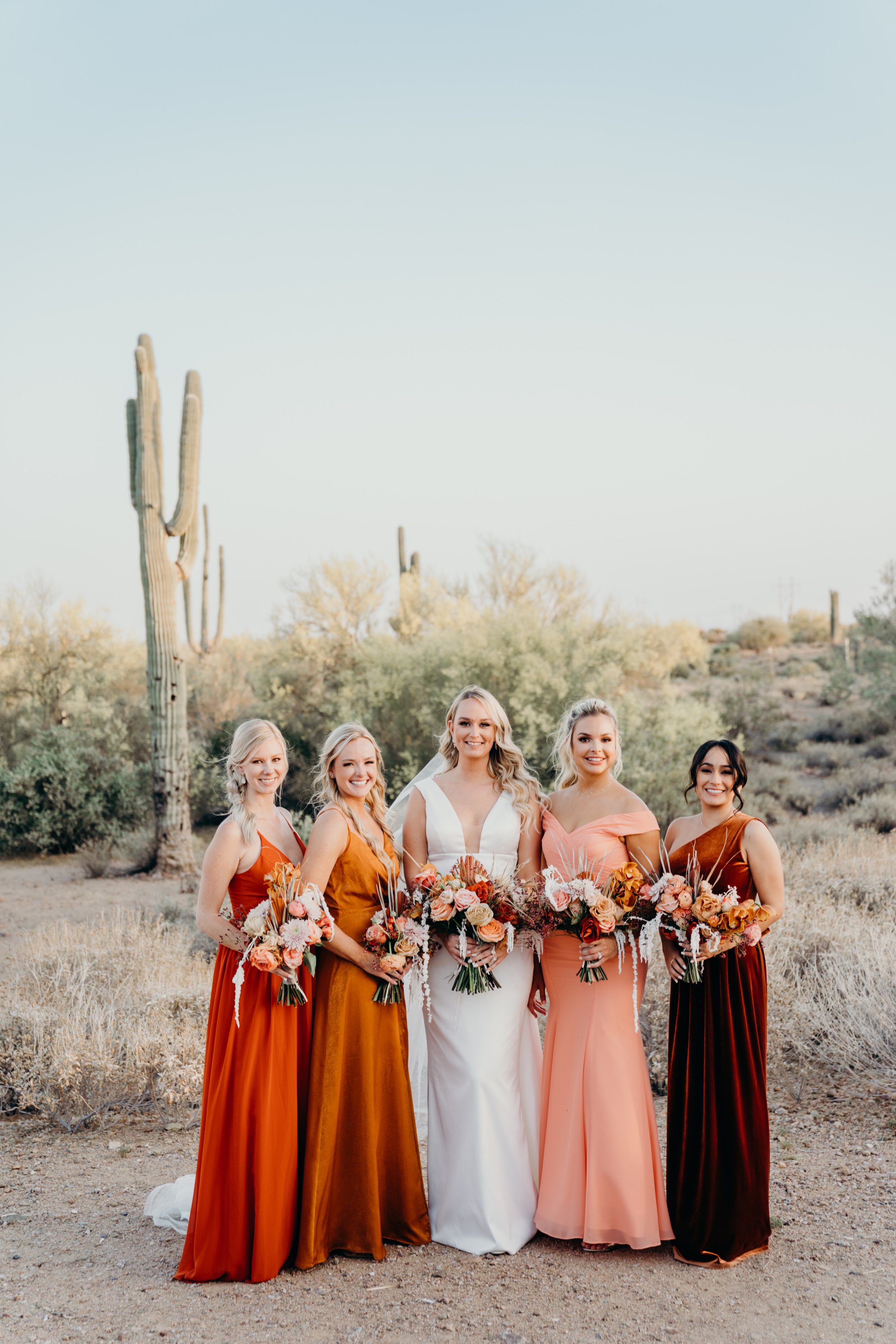 peach and pink bridesmaids with the bride in the arizona desert.