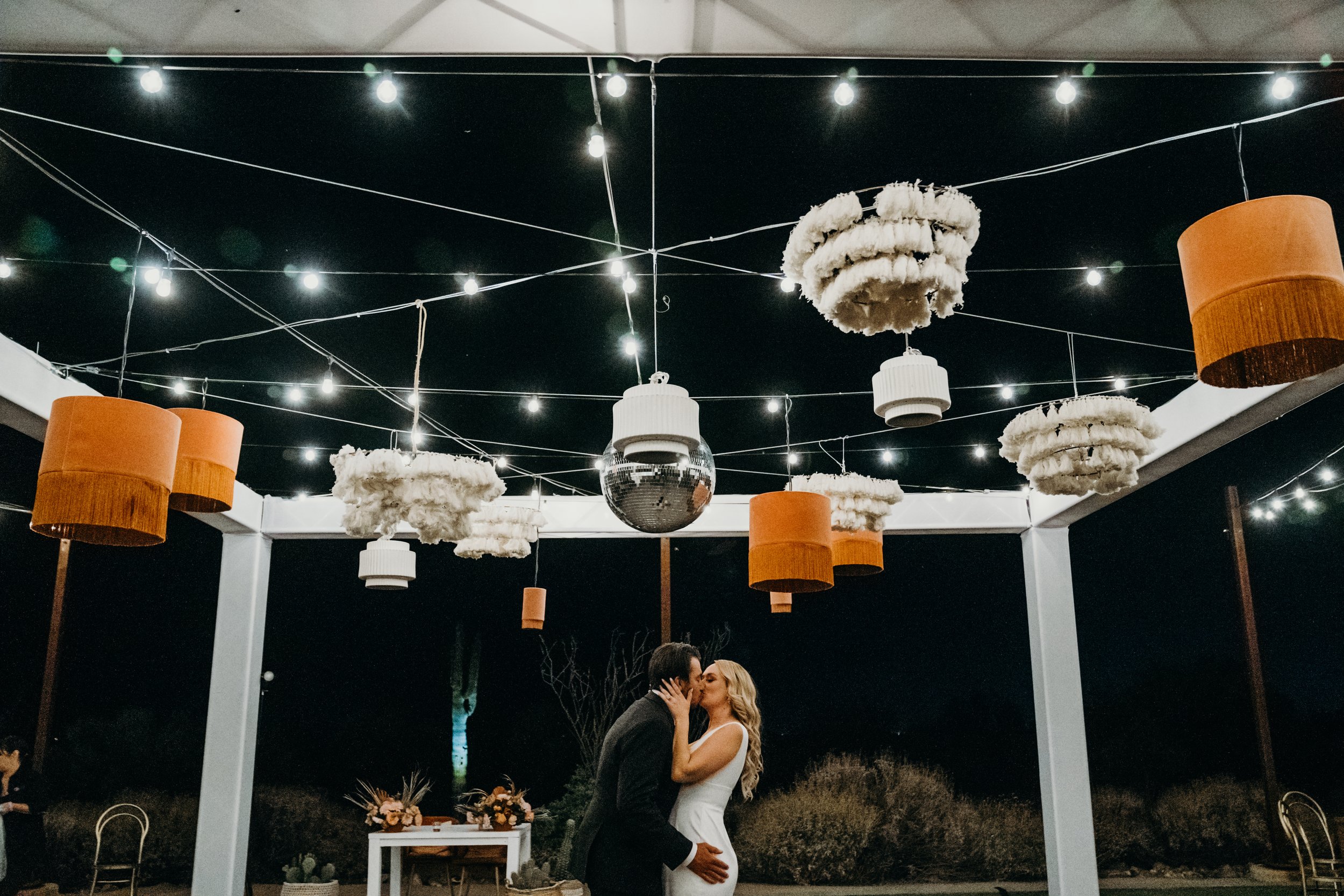 boho chandeliers and disco balls strung in the ceiling over the dance floor in this glam boho themed wedding in arizona.