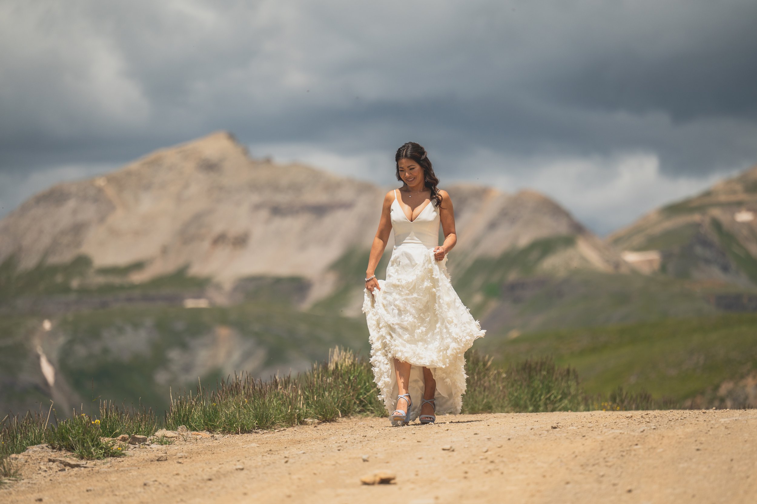 a small wedding on top of a mountain in colorado featuring a bride wearing a rebecca schoneveld wedding dress and light blue heels
