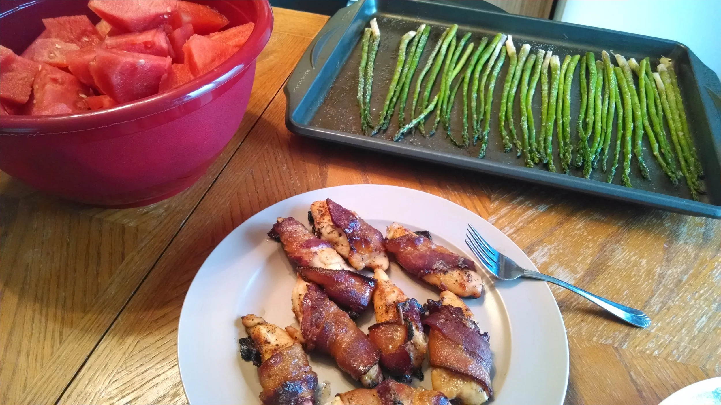 Bacon-wrapped chicken, baked garlic asparagus, and some watermelon