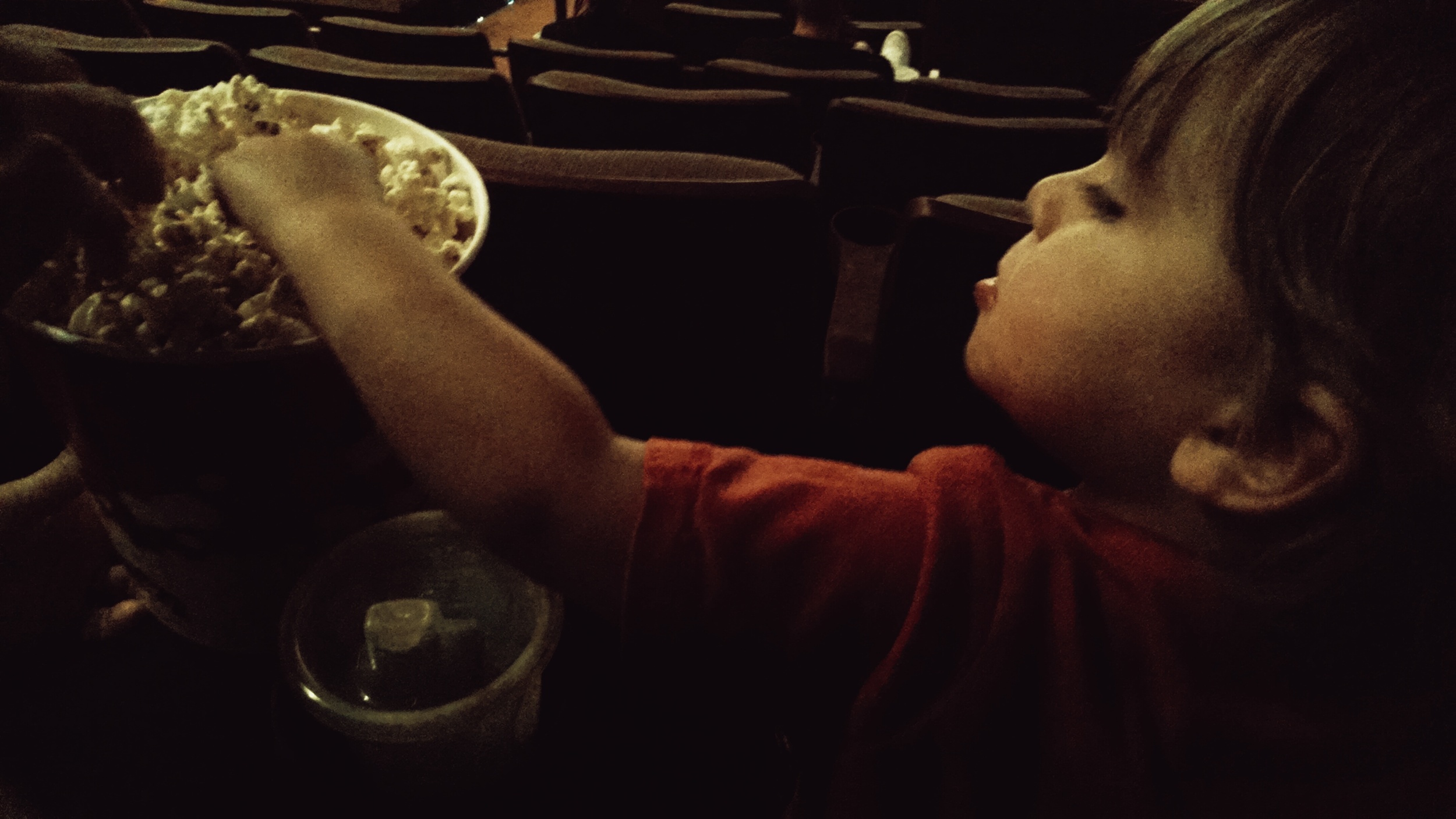 Eating popcorn at his first movie!