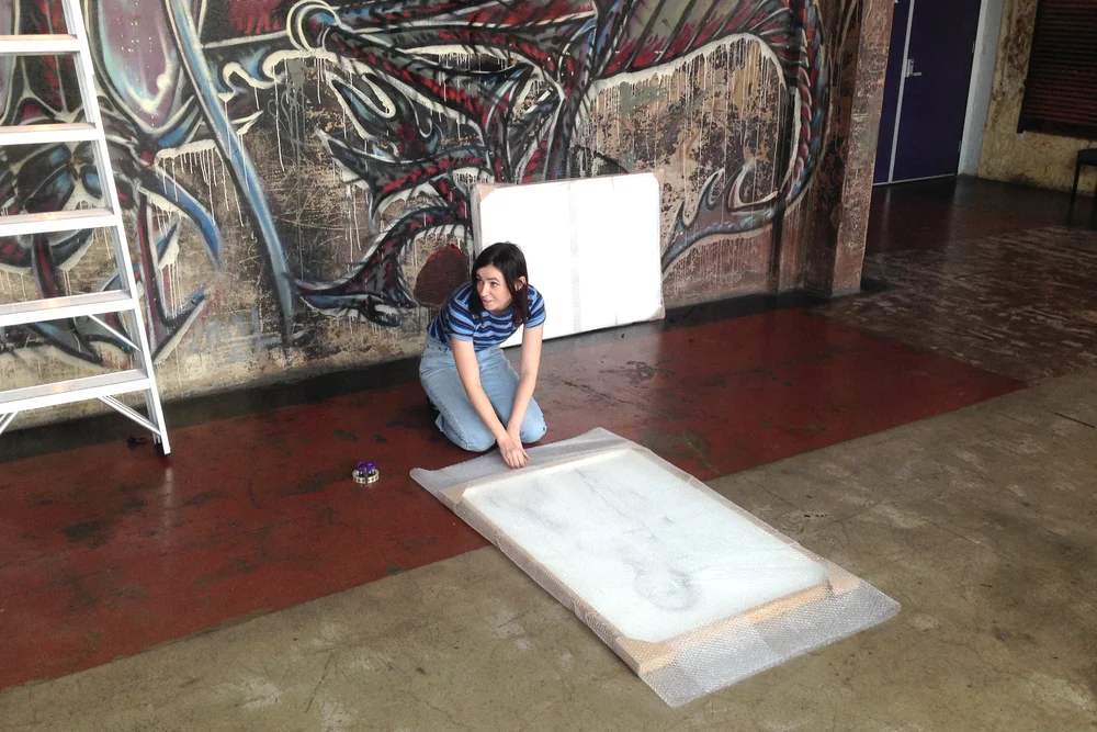 Alexandra Winters packing up an exhibition by Tyza at Brisbane Powerhouse.