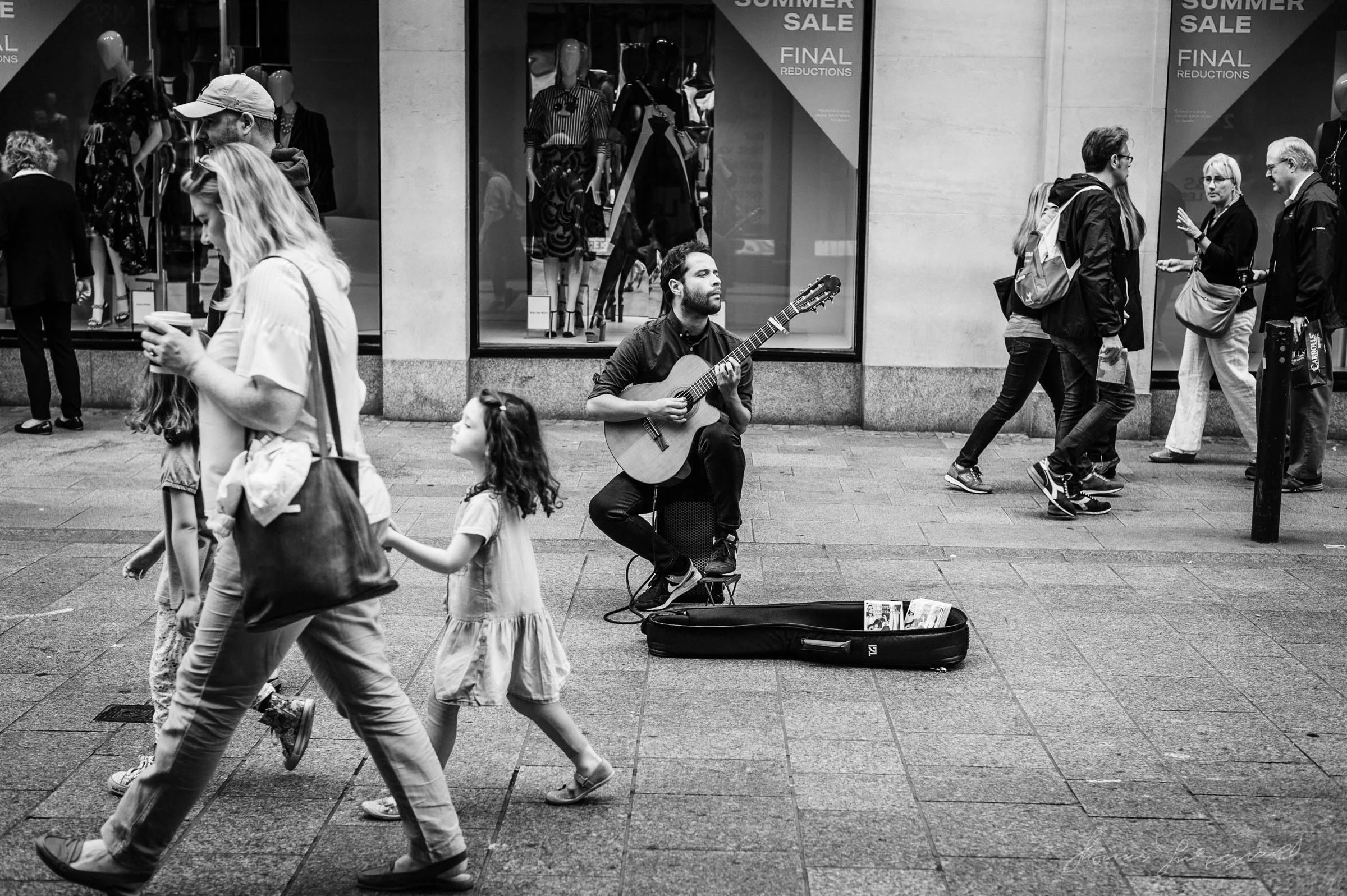 man playing guitar on Dublin's grafton street