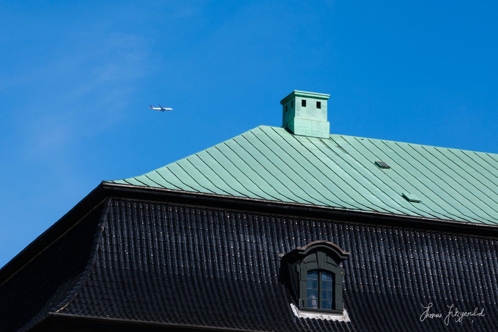 Airplane flying over the roof of the stables