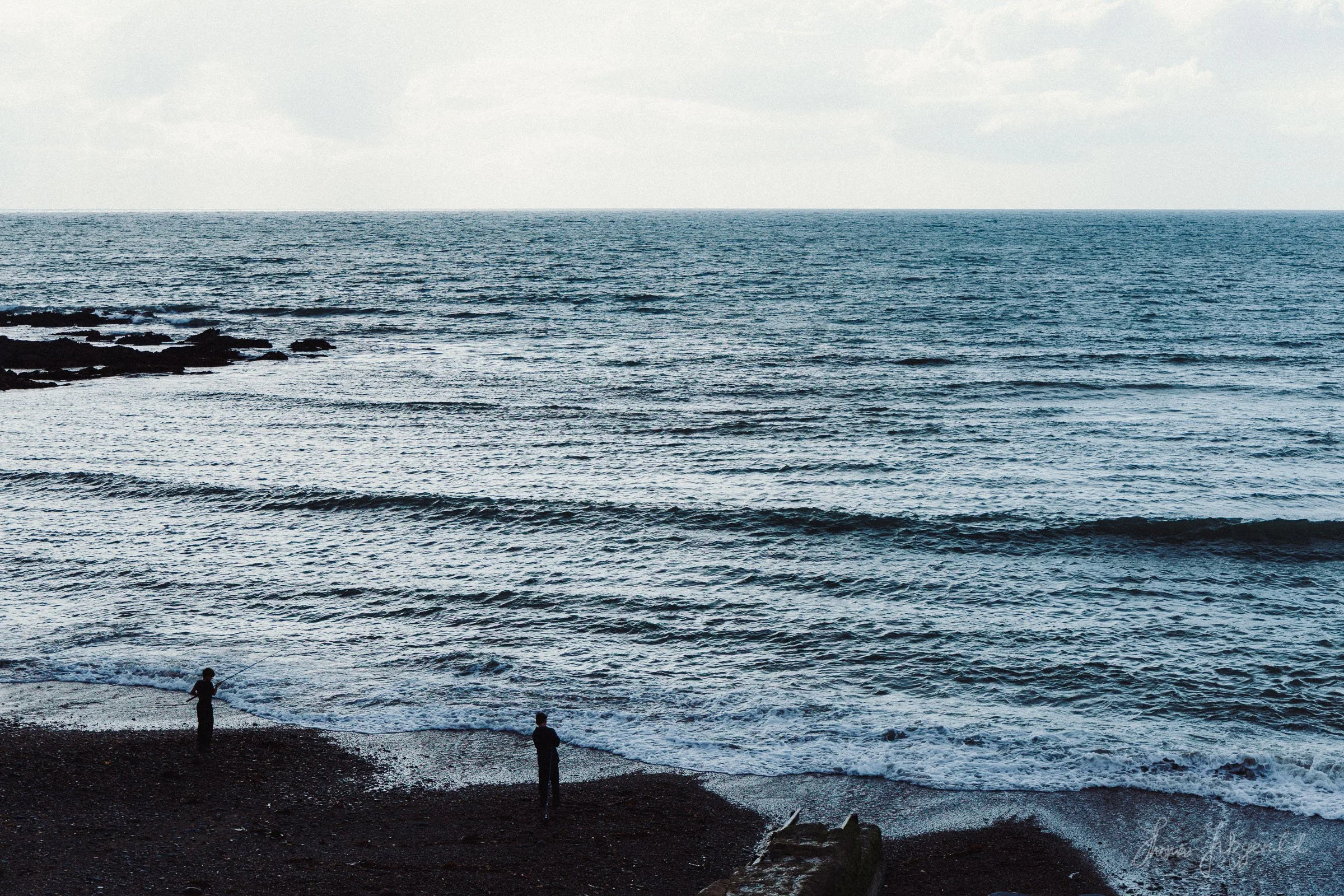 Some youths fishing in the sea at Aberystwyth