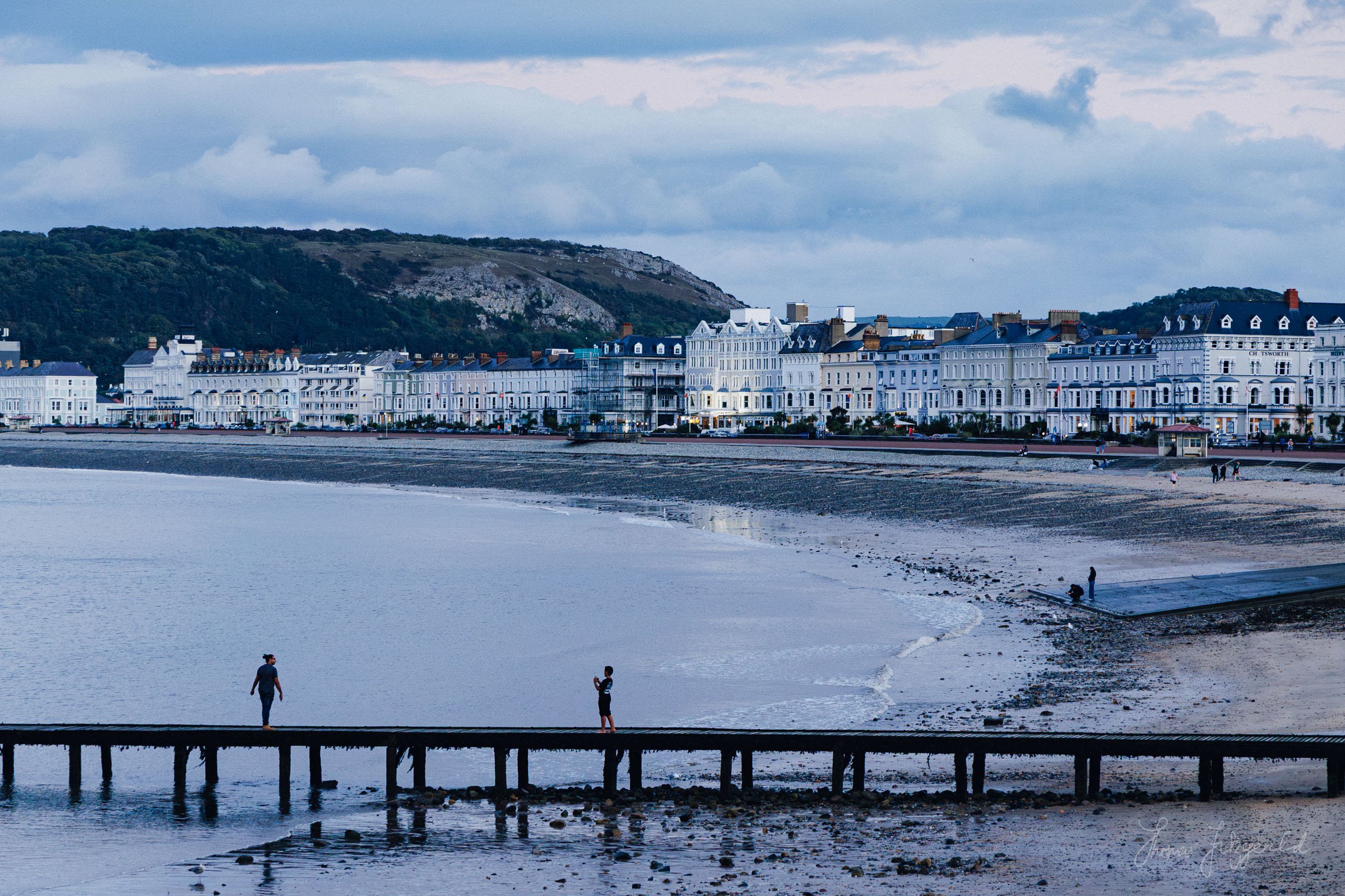 People on the wooden pier in front of the town of Llandudno