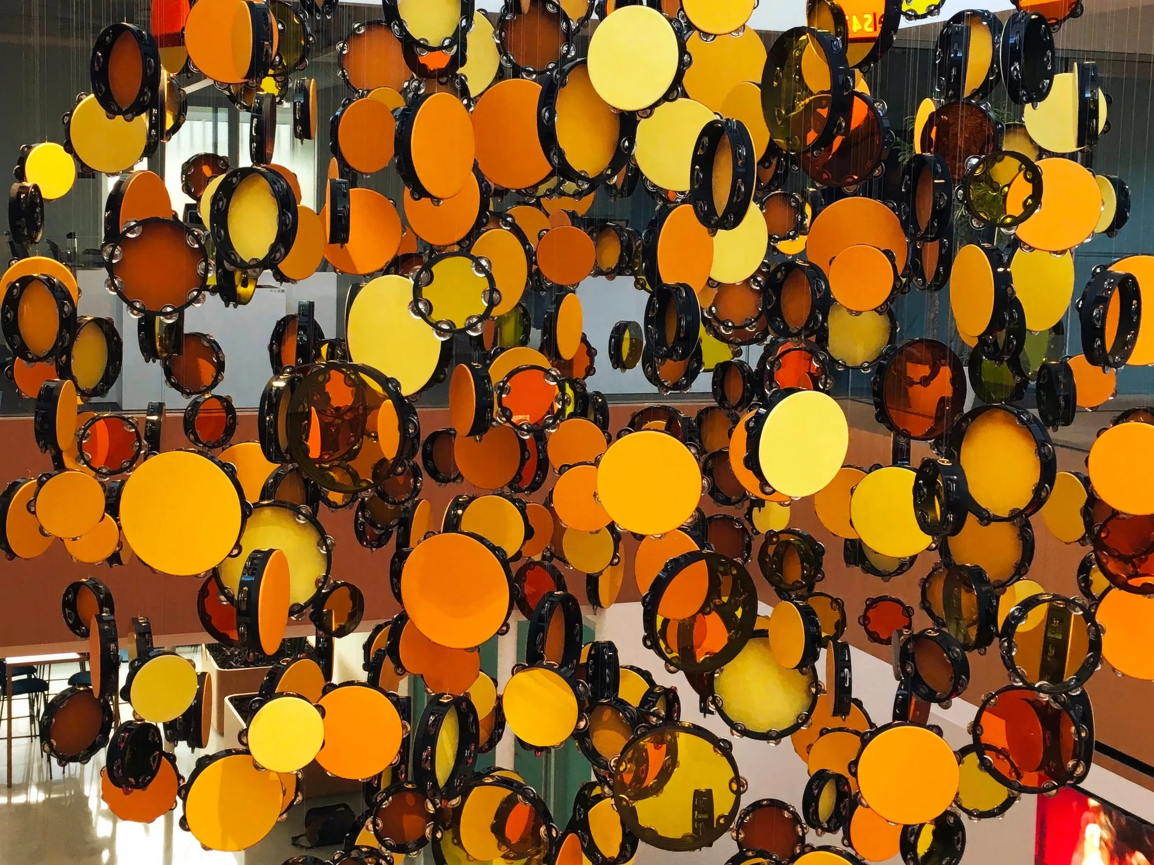   Feel What I Feel in the Sunshine , 2022. Tambourines, leather, suede, Plexiglas, mirrored acrylic, monofilament wire, S-hooks, aluminum grid, steel. Approx. 120” × 120” × 120” Installation view. Apple Music Headquarters, Culver City, CA. Placed by 