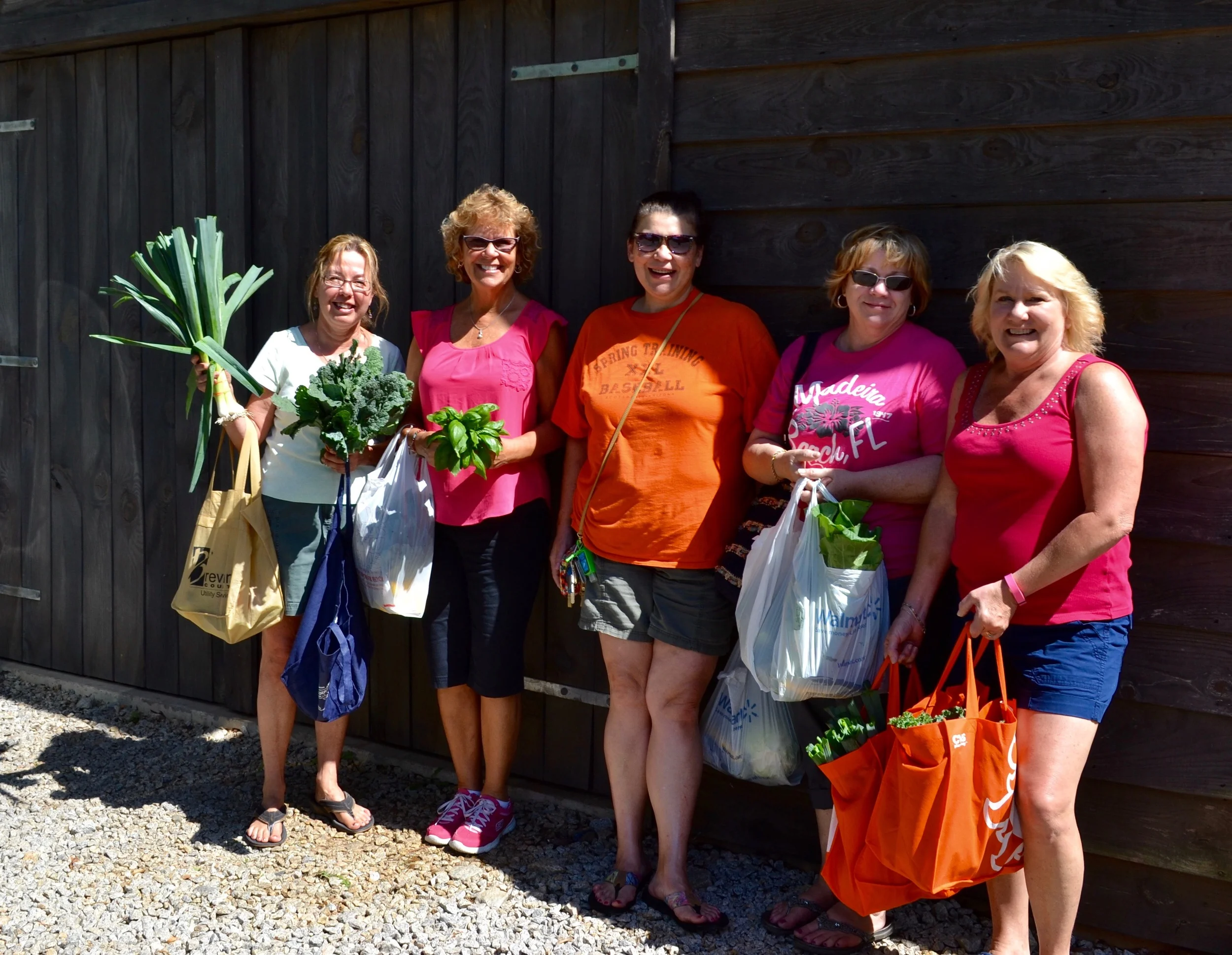 Happy customers are loaded up with freshly harvested vegetables from Elm Street Gardens.