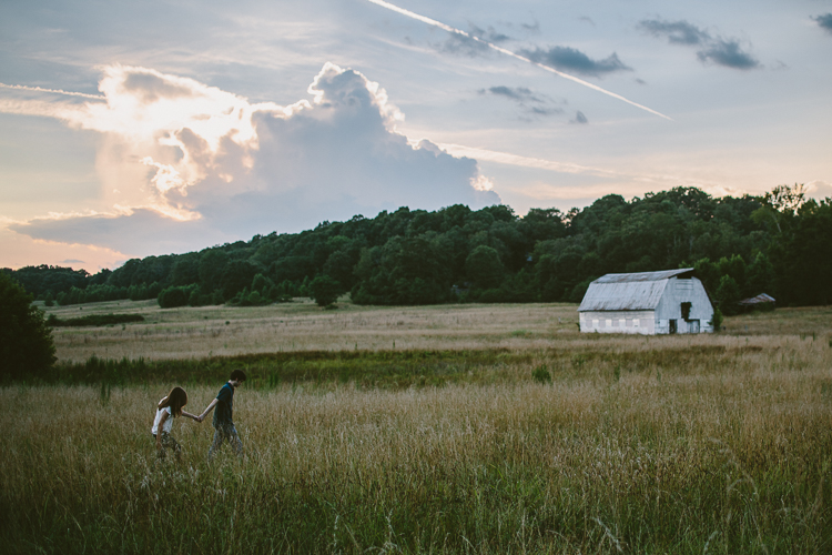 Couple Walking Through the Field with a Barn