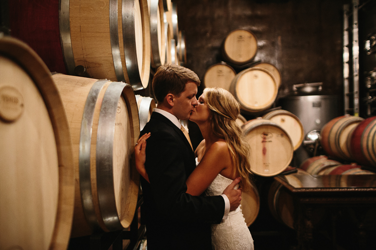 The Bride and Groom Sharing a Sweet Kiss in the Wine Cellars