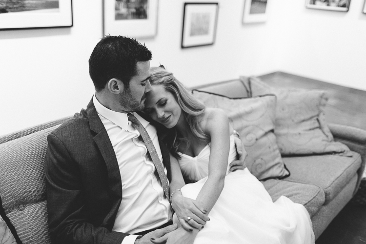 Bride and groom getting cozy at art gallery reception