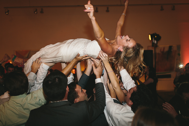 Bride crowd surfing at reception