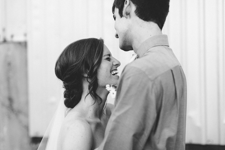Black and white portrait of bride and groom laughing together