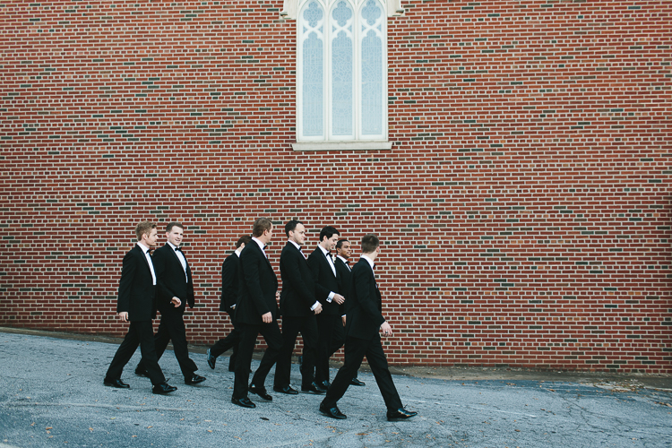 groom and groomsmen walking down the street together