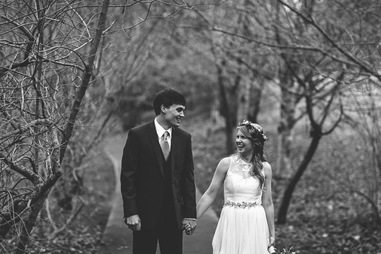 bride and groom walking down sidewalk holding hands