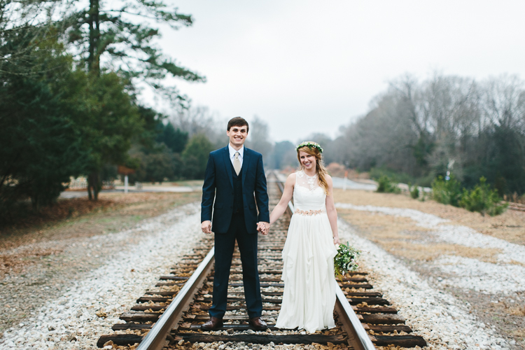 bride and groom on railroad tracks