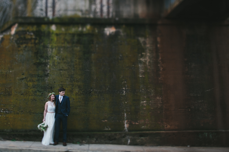 bride and groom by old concrete wall