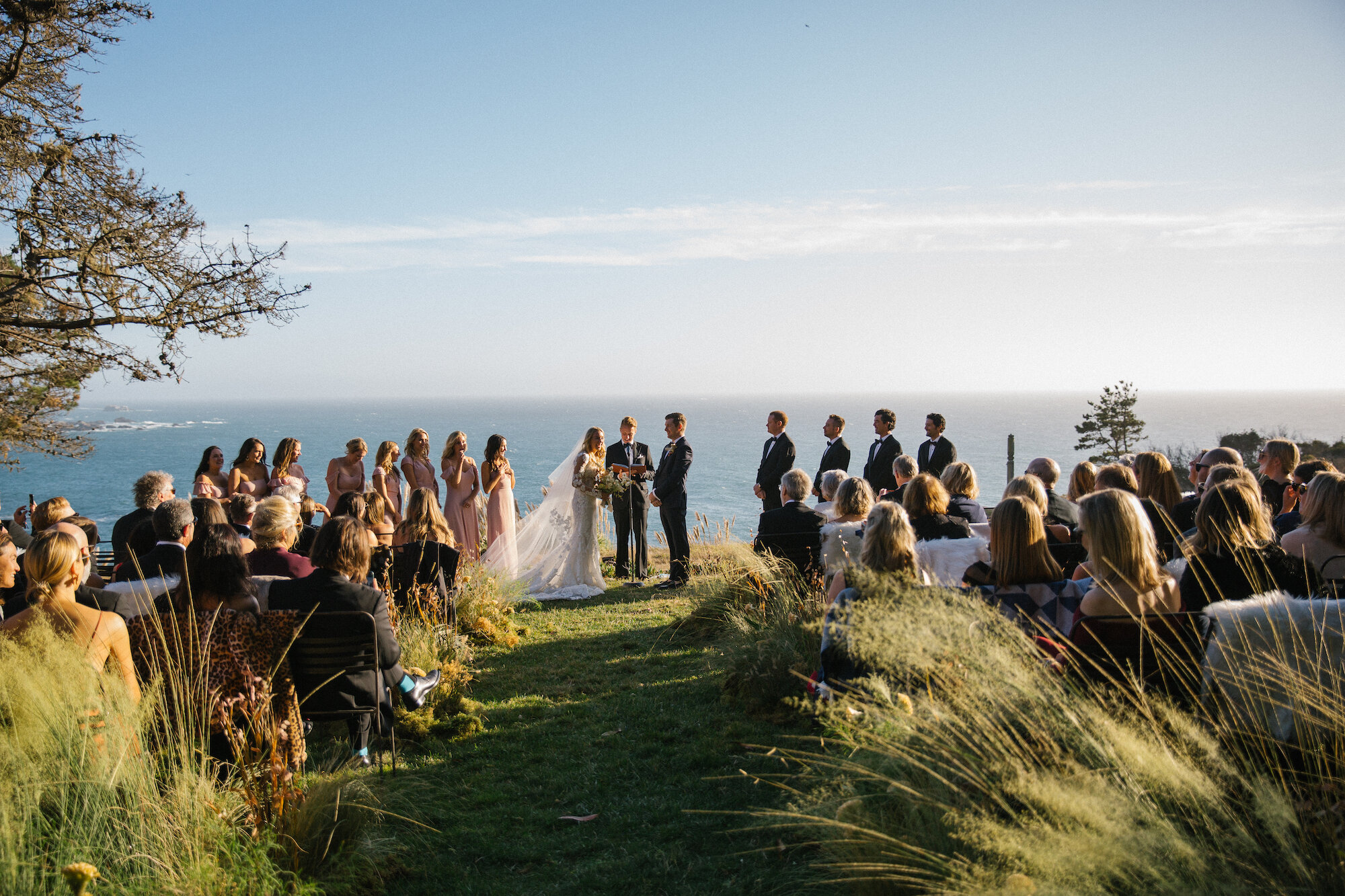  When the California coast is the ultimate altar vista, redirect your floral treatment to the aisle. An immersive aisle grass installation swayed gently with the breeze.     Photo by Jesse Leak. Event Design by Bash Please. 