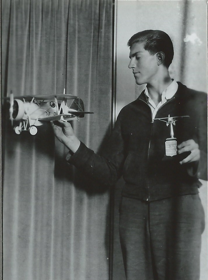 Dad, at age 17, with the trophy and the model airplane he built to win it. It took him a year to build it from scratch. 